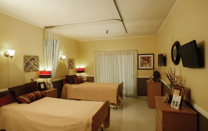 A cozy bedroom with two twin beds, decorated with warm tones and stylish furniture.