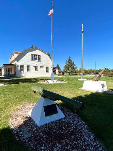 An outdoor military exhibit featuring artillery pieces at a historic museum on a sunny day.