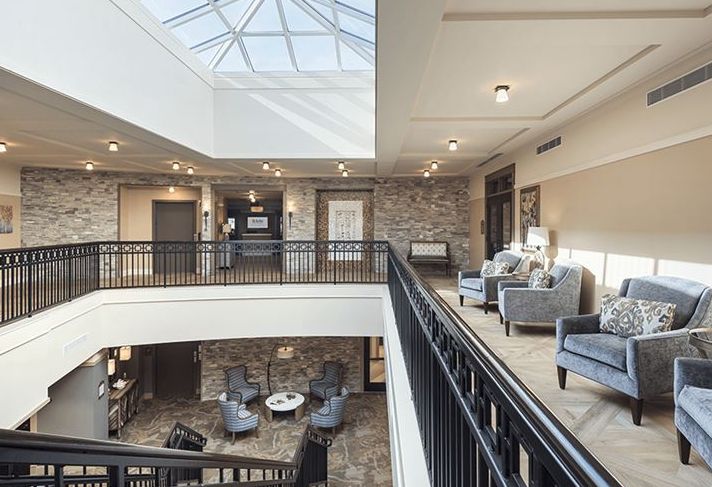 A modern lobby area with comfortable seating and a large skylight.
