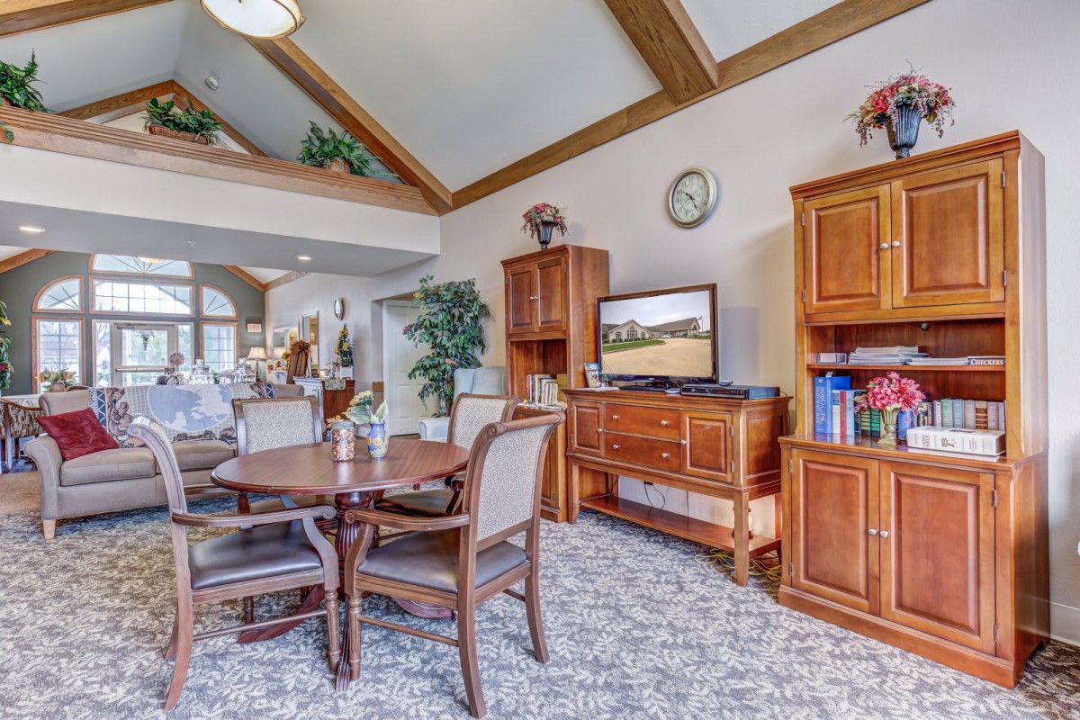 A cozy living room featuring wooden furniture, a television, and comfortable seating with decorative elements.