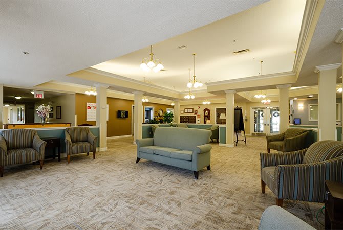 A spacious and elegantly designed lobby with comfortable seating areas, featuring sofas and armchairs, under warm lighting.