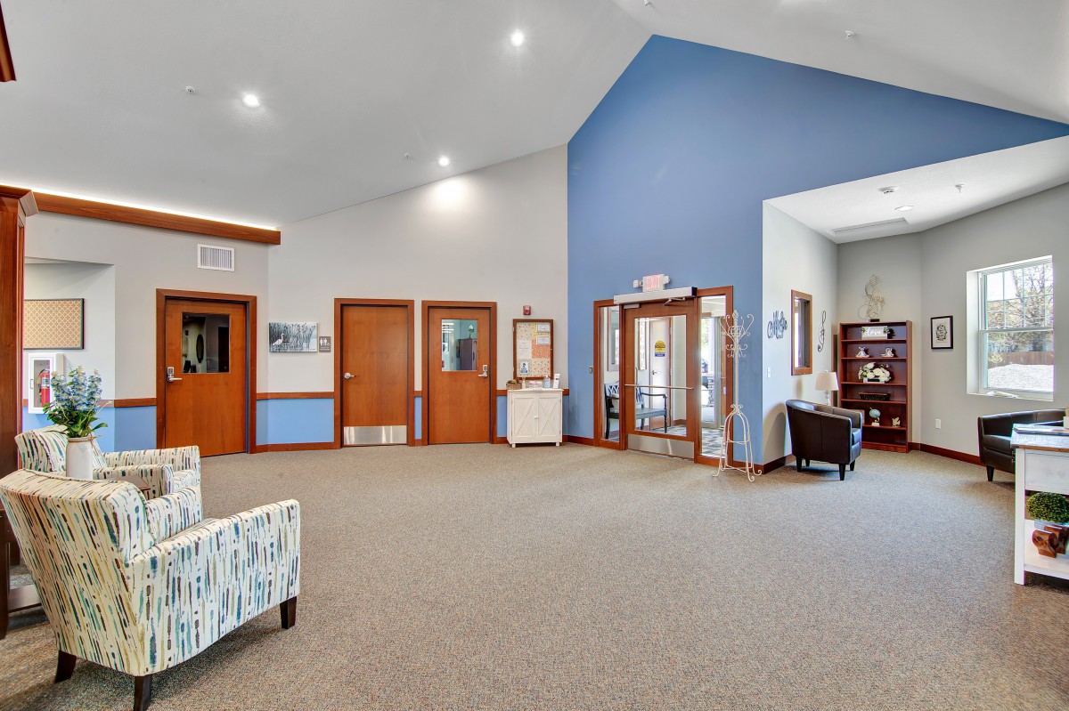 A spacious lobby area with seating and wooden doors, featuring a welcoming atmosphere.
