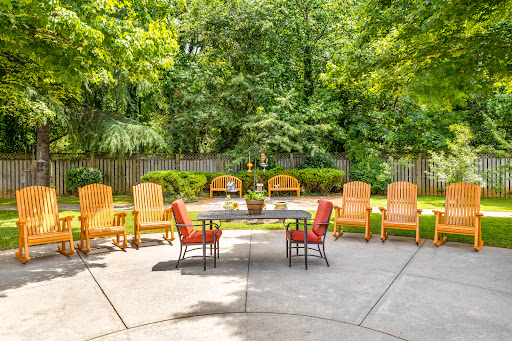 A serene outdoor patio area featuring comfortable seating surrounded by lush greenery.