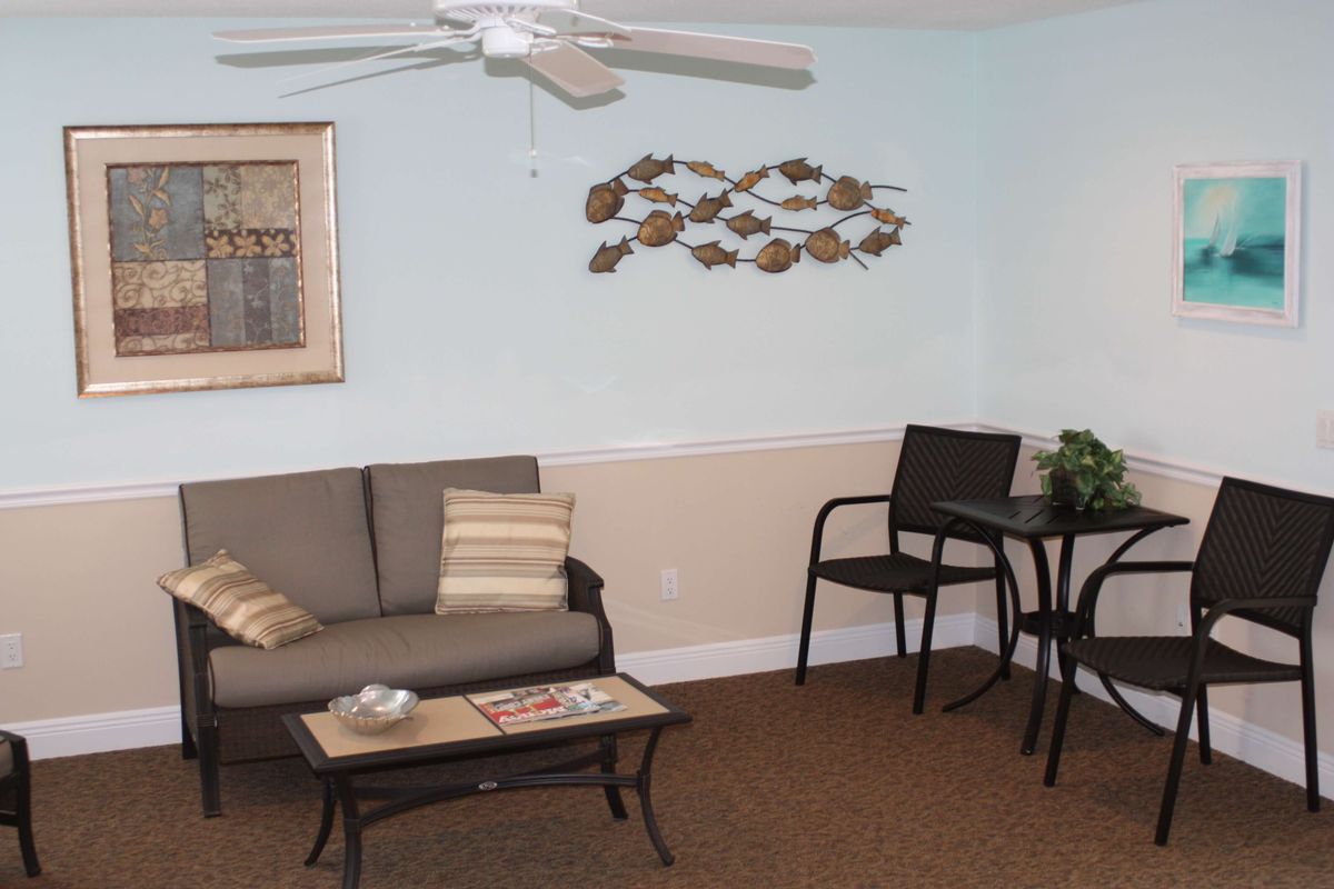 A cozy living room with a sofa, chairs, and artistic wall decorations.