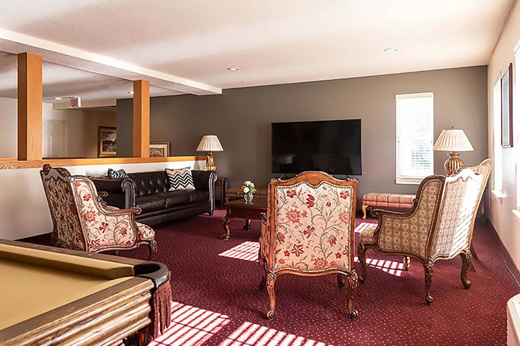 A cozy living room featuring a large TV, comfortable seating, and elegant decor.
