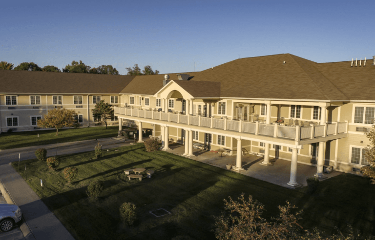A large, elegant building with a spacious lawn and impressive columns.