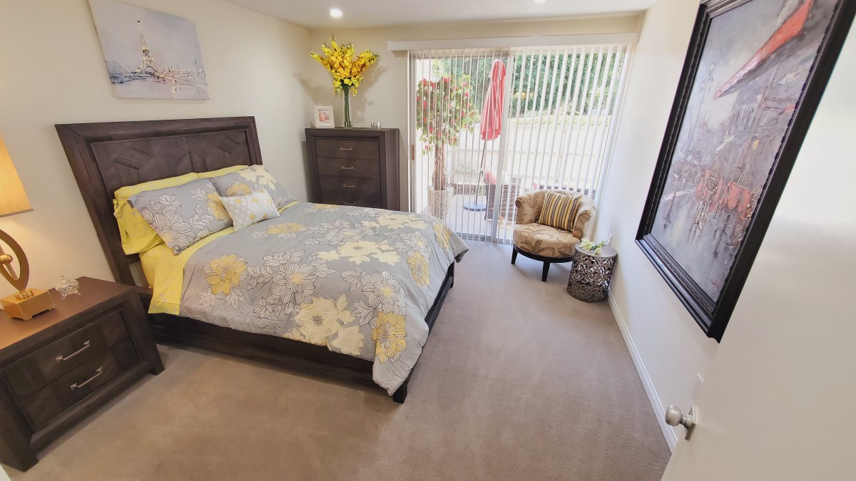 A cozy bedroom with a floral-themed bedspread and elegant decor.