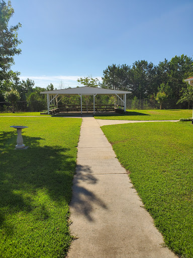 A serene view of a park featuring a charming gazebo and a well-maintained pathway surrounded by lush green grass.