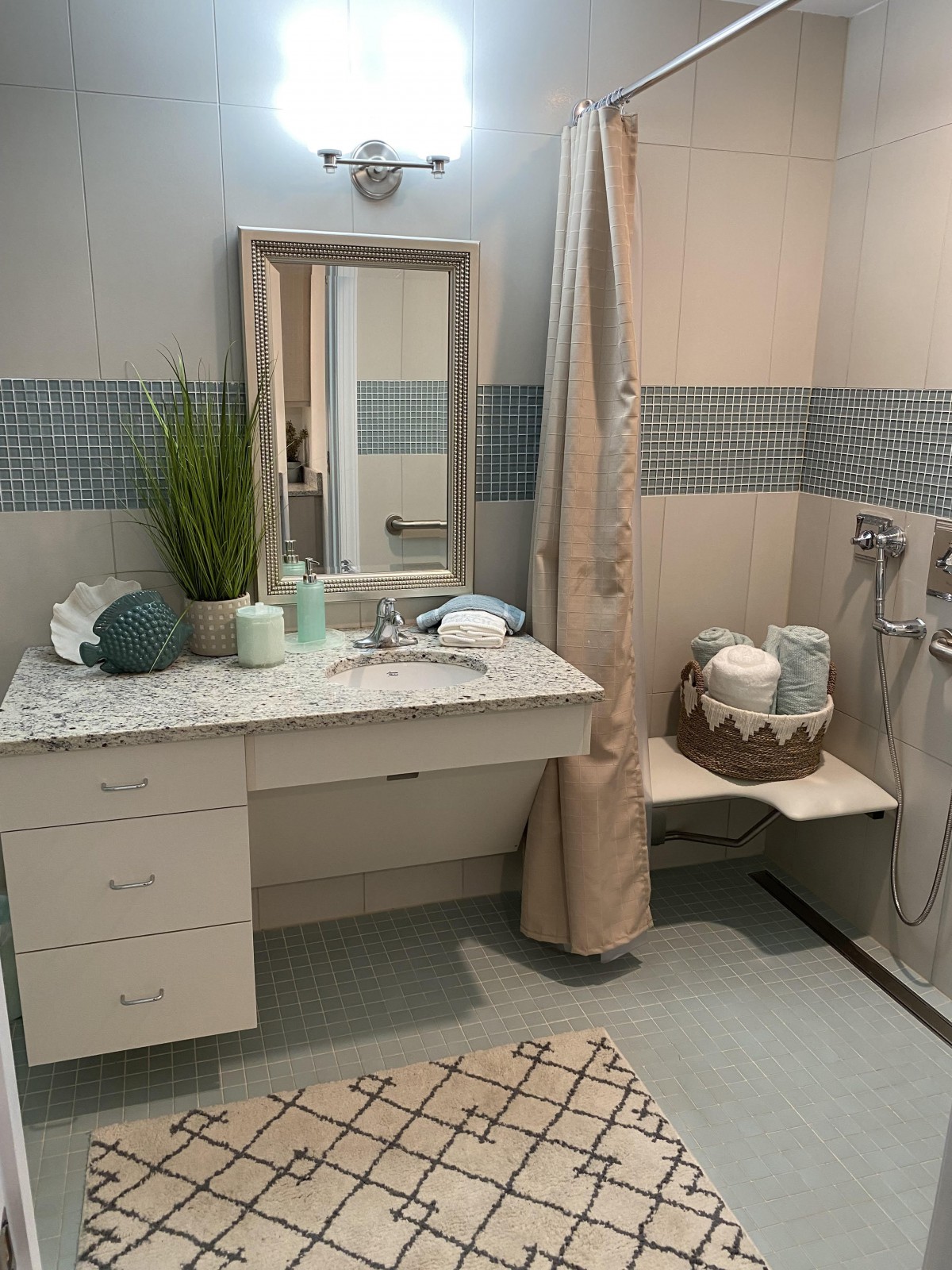 A neatly organized bathroom with a large mirror, countertop decor, and a shower area.
