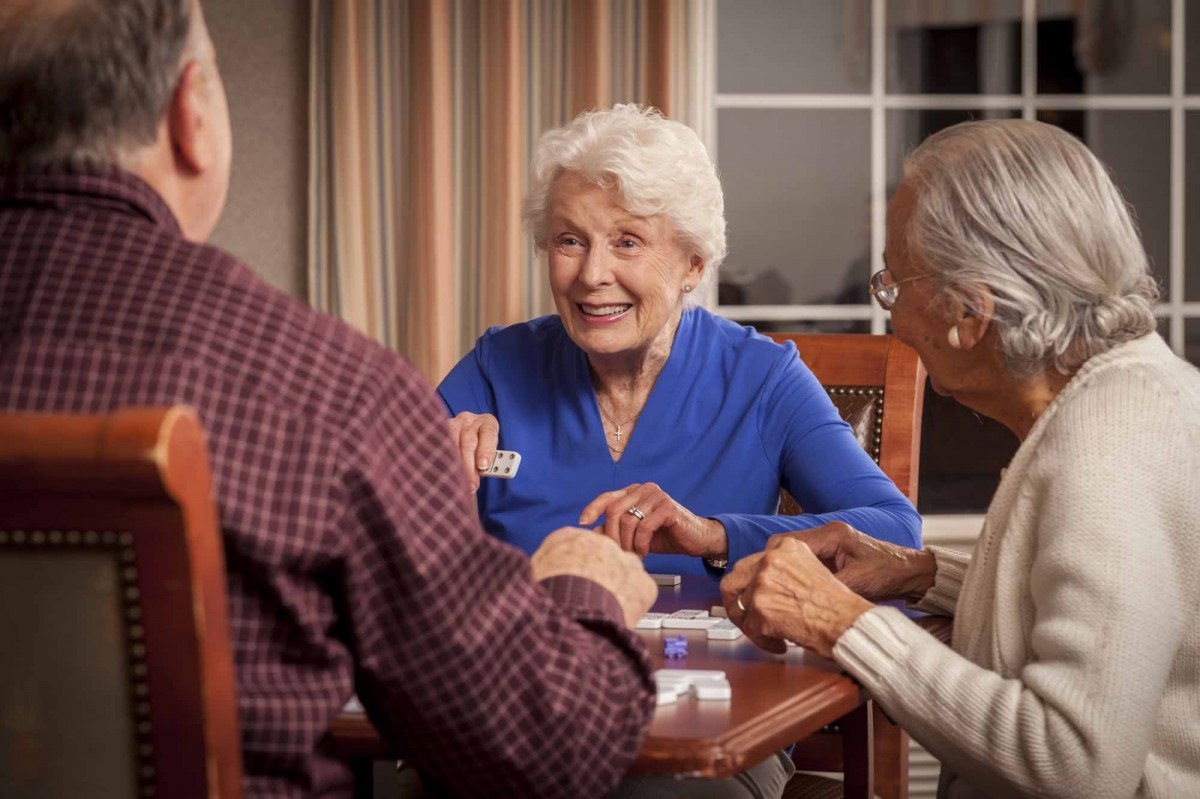 A group of elderly people enjoying a game together indoors.