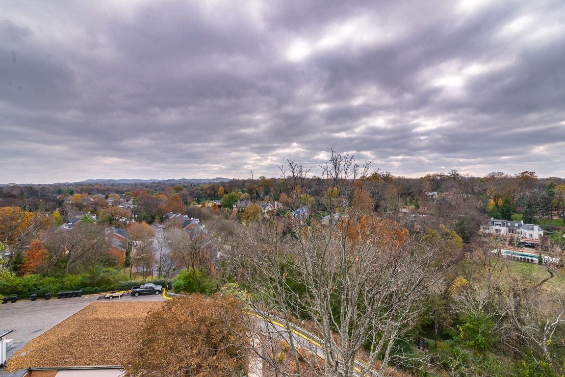 Overcast sky above a suburban landscape with autumn foliage.