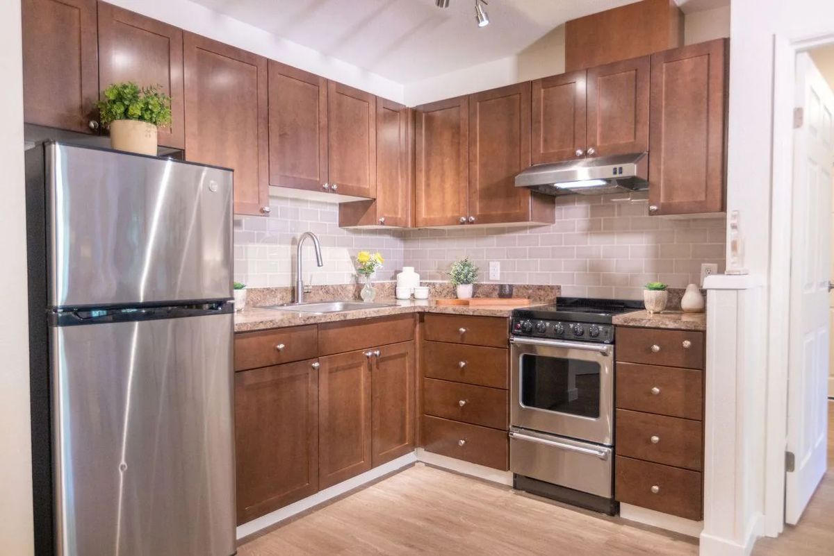 A modern kitchen with wood cabinets and stainless steel appliances.