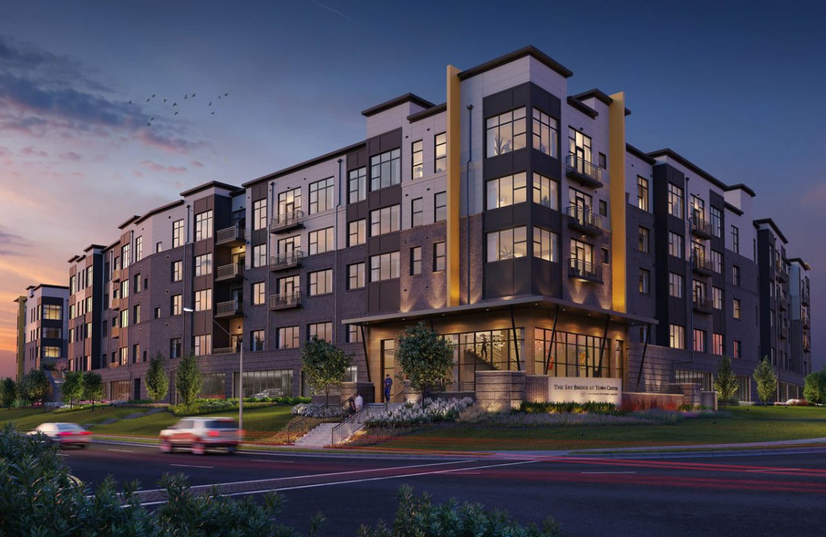 A modern apartment building illuminated during the evening.