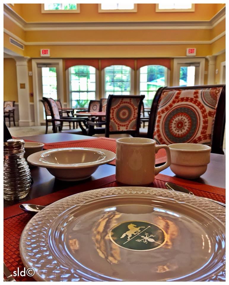 A beautifully set dining room with patterned chairs and elegantly arranged tableware, capturing a warm and inviting atmosphere.