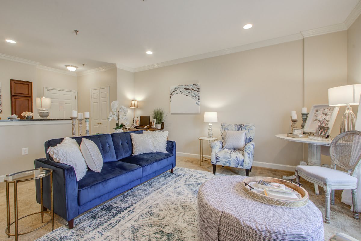 A cozy and elegantly designed living room featuring a blue sofa, patterned armchair, and stylish decor.