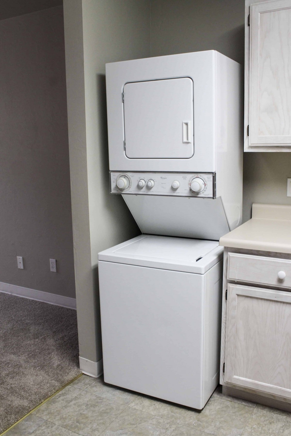 A stacked washer and dryer unit in a home laundry area.