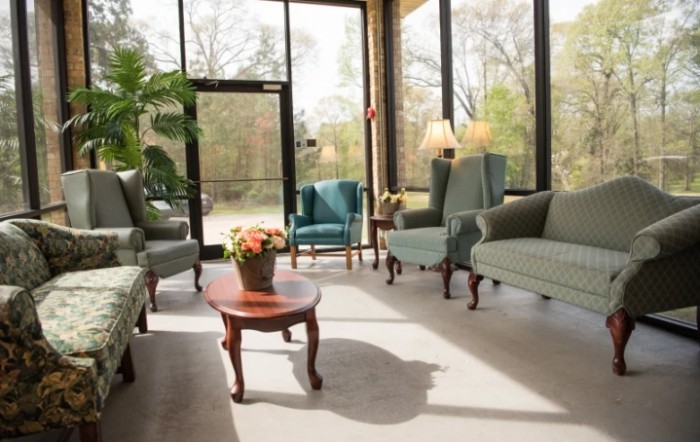 A well-lit waiting room with comfortable seating and large windows.