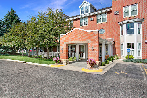A welcoming entrance to a hotel featuring red brick architecture and landscaped surroundings.