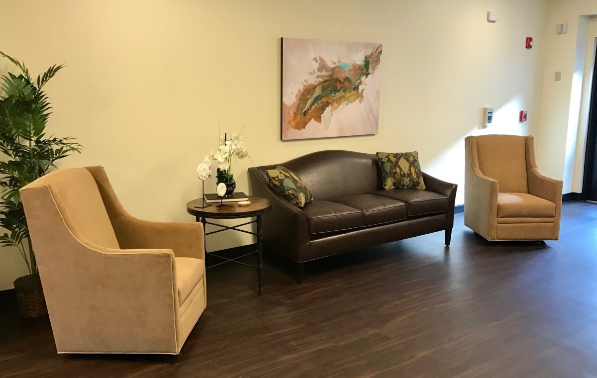 A cozy waiting room with a sofa, chairs, and elegant decor.