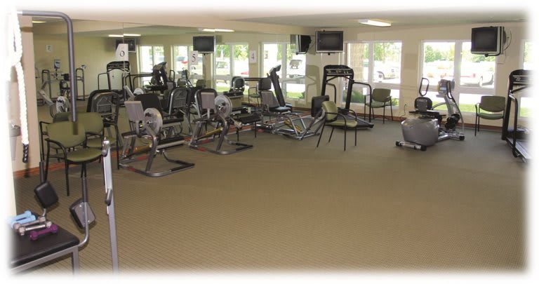 A spacious gym area equipped with various exercise machines and fitness equipment.