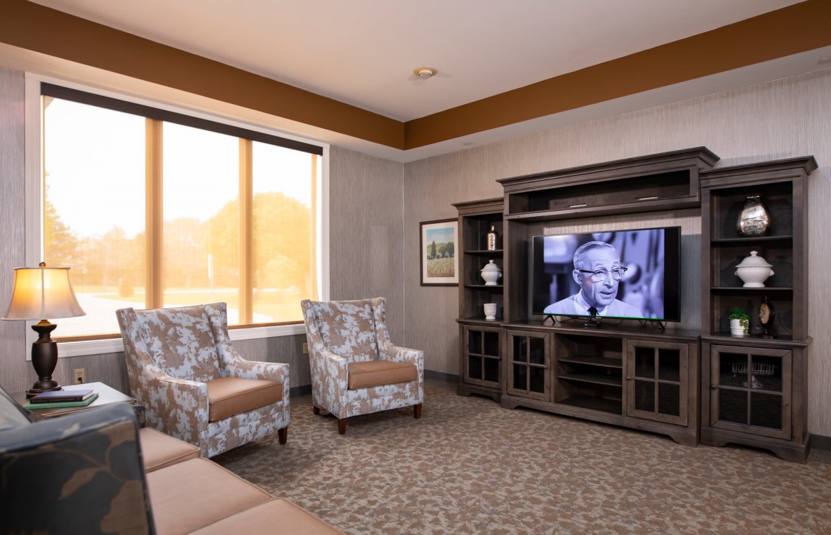 A cozy living room with armchairs and a television.