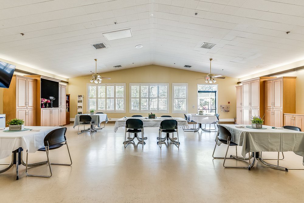 A spacious community center room with tables and chairs arranged for an event.