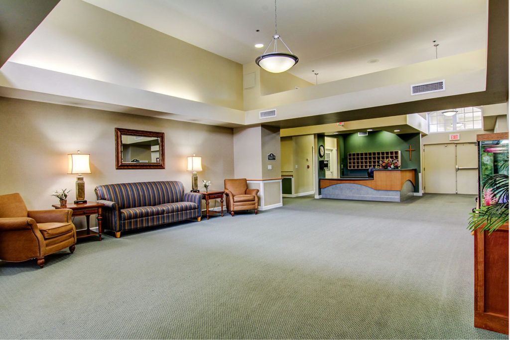 A spacious hotel lobby with comfortable seating and a reception desk.