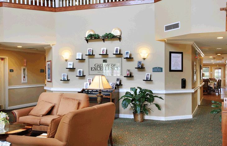 A cozy lobby with comfortable seating, decorative shelves, and indoor plants.