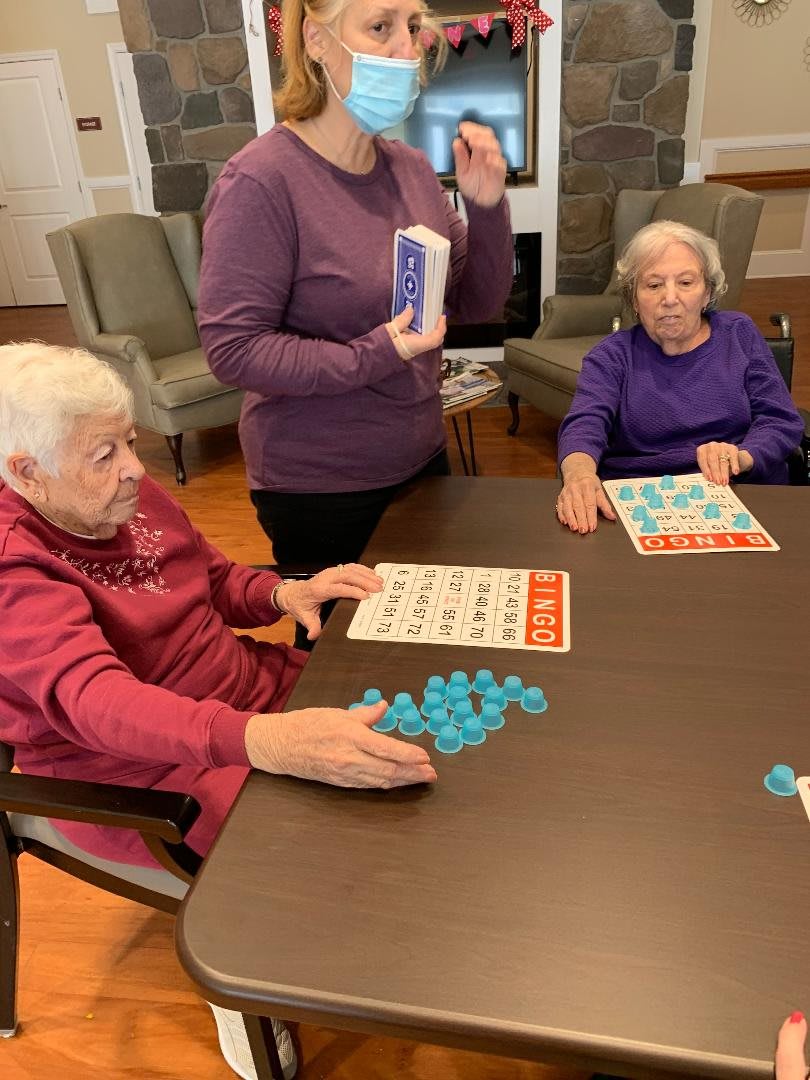 A group of elderly women playing bingo together in a cozy setting.