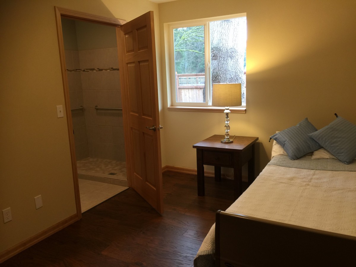 A cozy bedroom with a bed, nightstand, and an open closet.