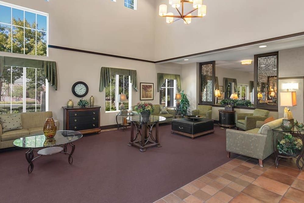 A spacious and elegantly decorated living room with comfortable seating and a high ceiling.