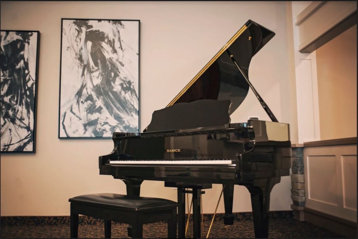 A grand piano in a music room with abstract artwork on the wall.
