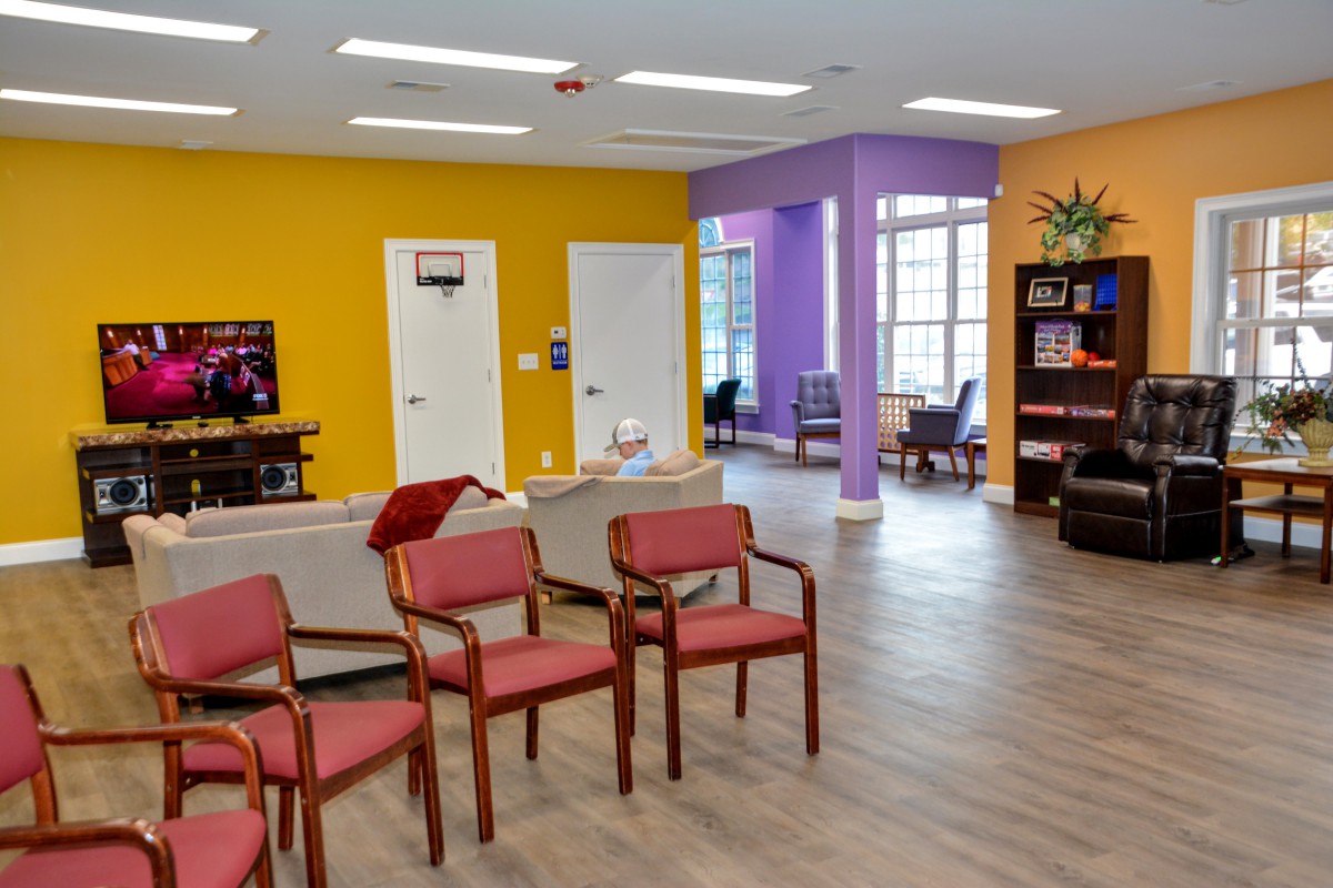 A colorful waiting room with chairs arranged neatly and bright walls.