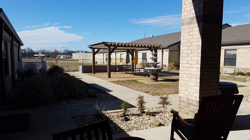 A serene backyard featuring a pergola and a well-maintained landscape under a clear blue sky.