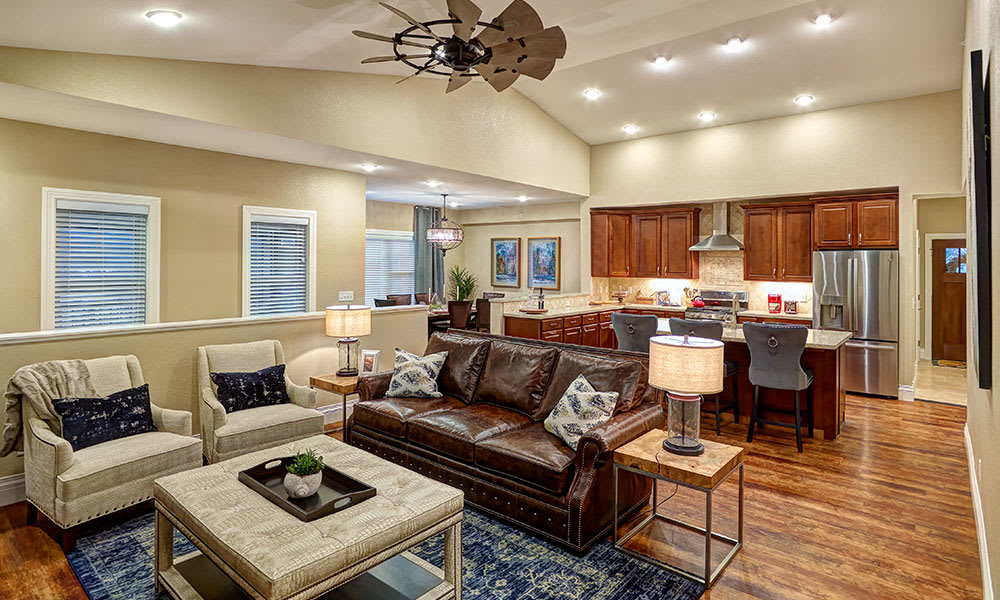 A cozy open-concept living room and kitchen with modern decor and a leather sofa.