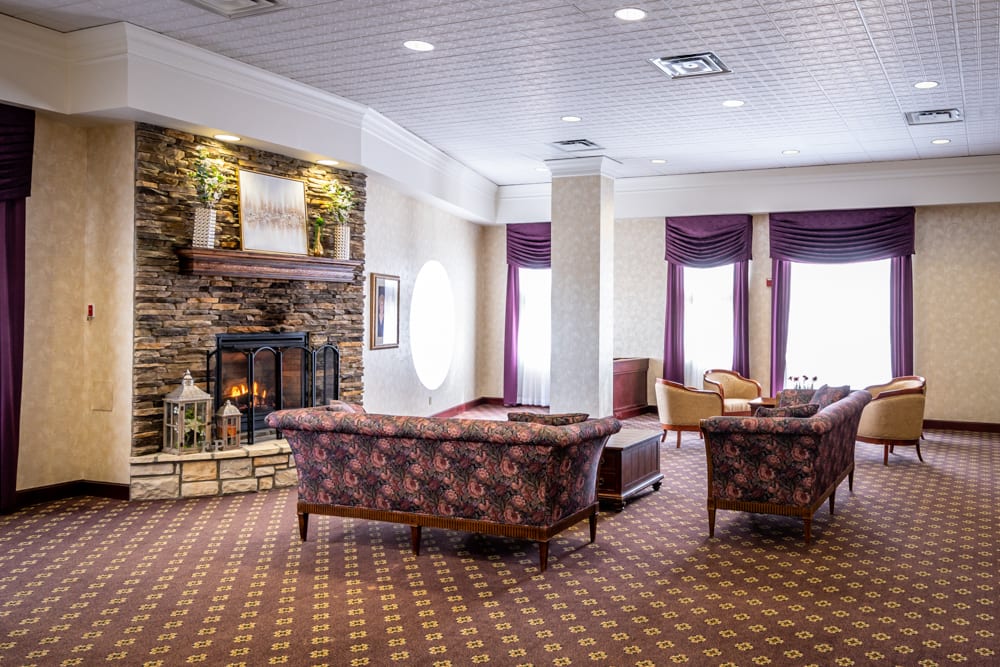 A cozy lounge area with sofas, armchairs, and a fireplace.