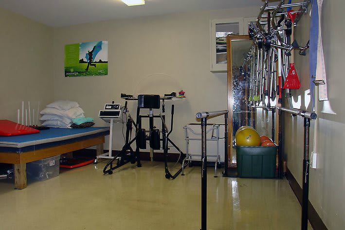 A well-equipped physical therapy room with various exercise equipment.
