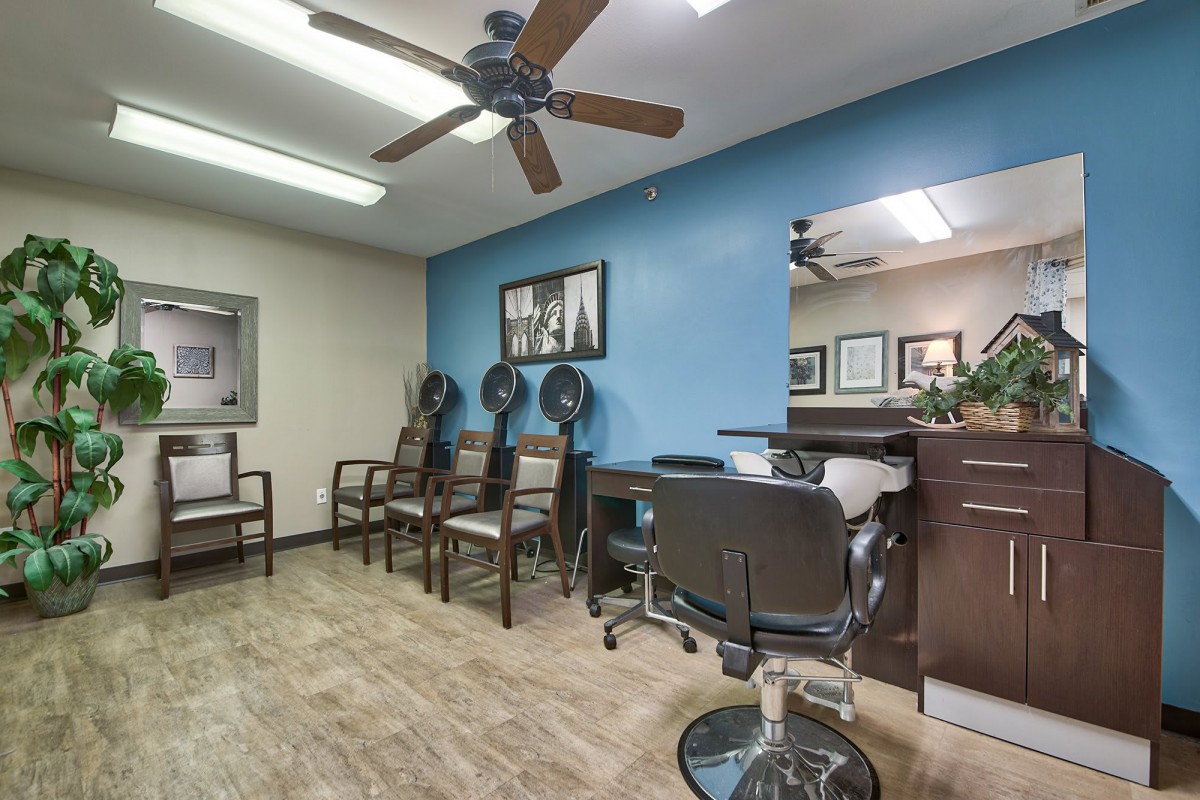 Hair salon interior with chairs, hair dryers, and a blue accent wall.