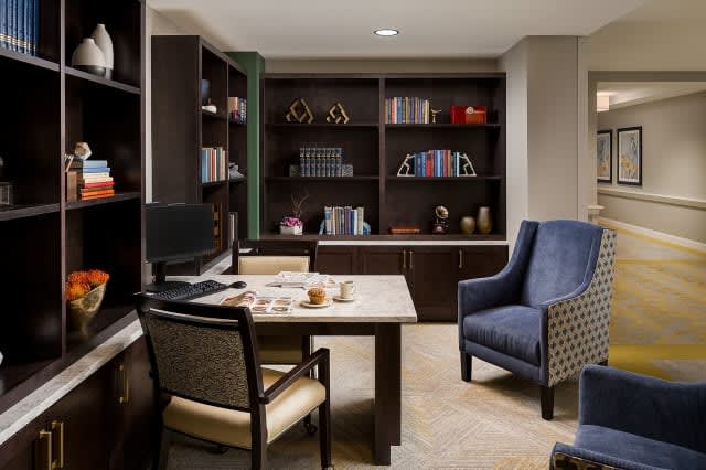 A well-organized office space with bookshelves and comfortable seating.