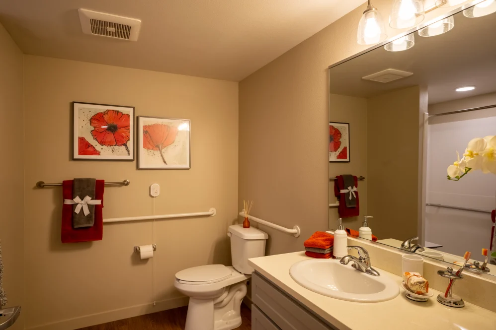 Modern bathroom with artwork and warm lighting.