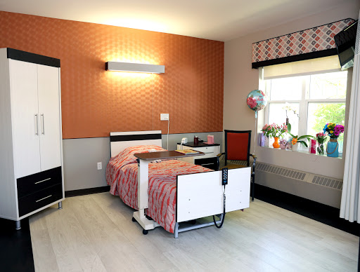 A well-designed hospital patient room featuring modern furnishings and a bright window.
