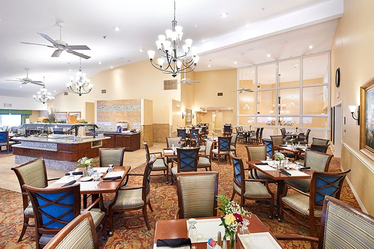Elegant dining area with chandeliers and neatly arranged tables and chairs.