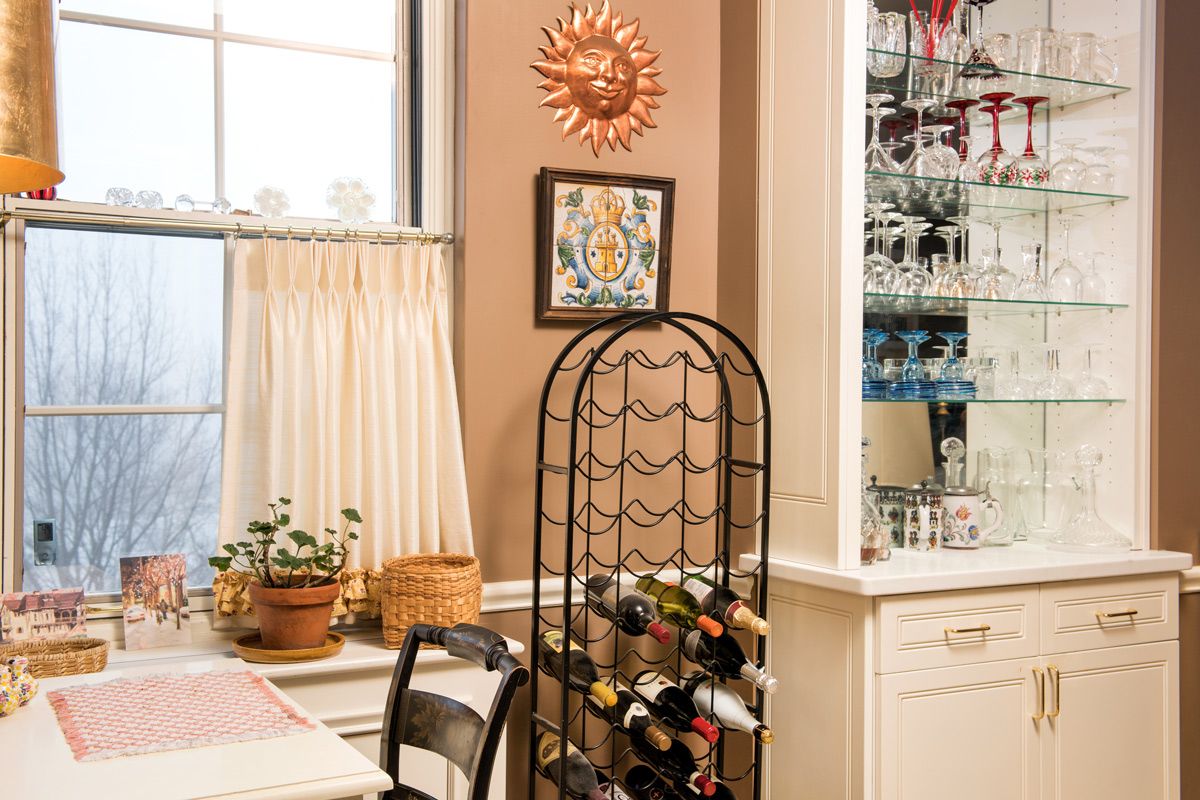 A cozy kitchen corner featuring a wine rack, potted plants, and decorative wall art.