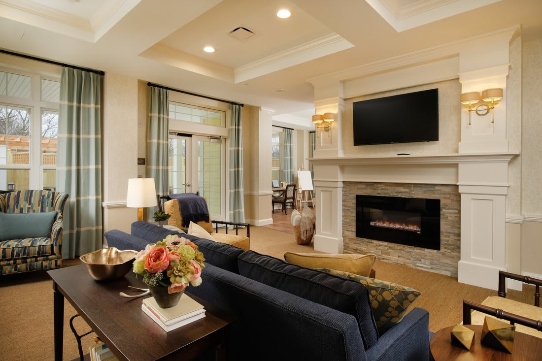 A modern living room featuring a fireplace and television, with cozy furniture and elegant decor.