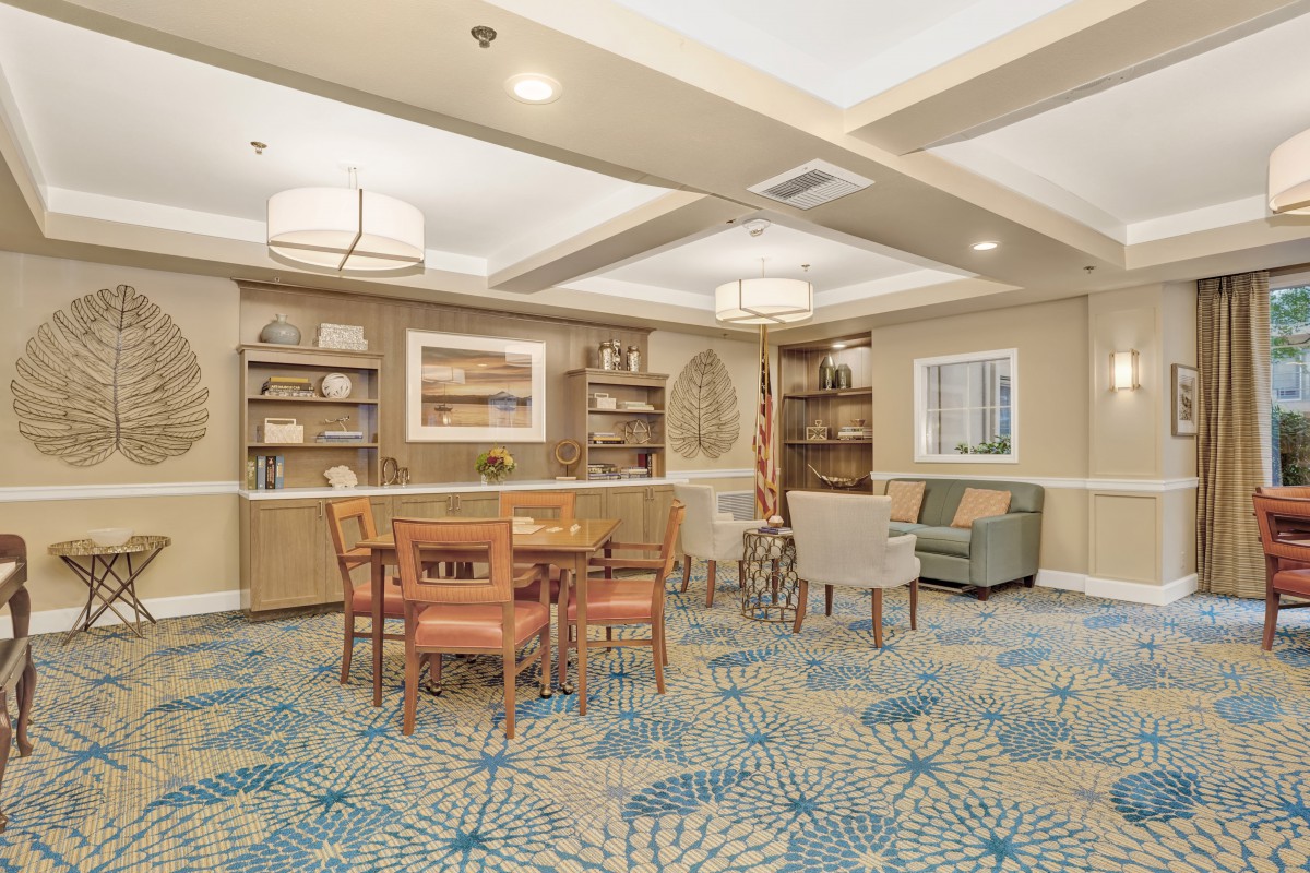 A cozy library reading area with bookshelves, a table, and chairs.
