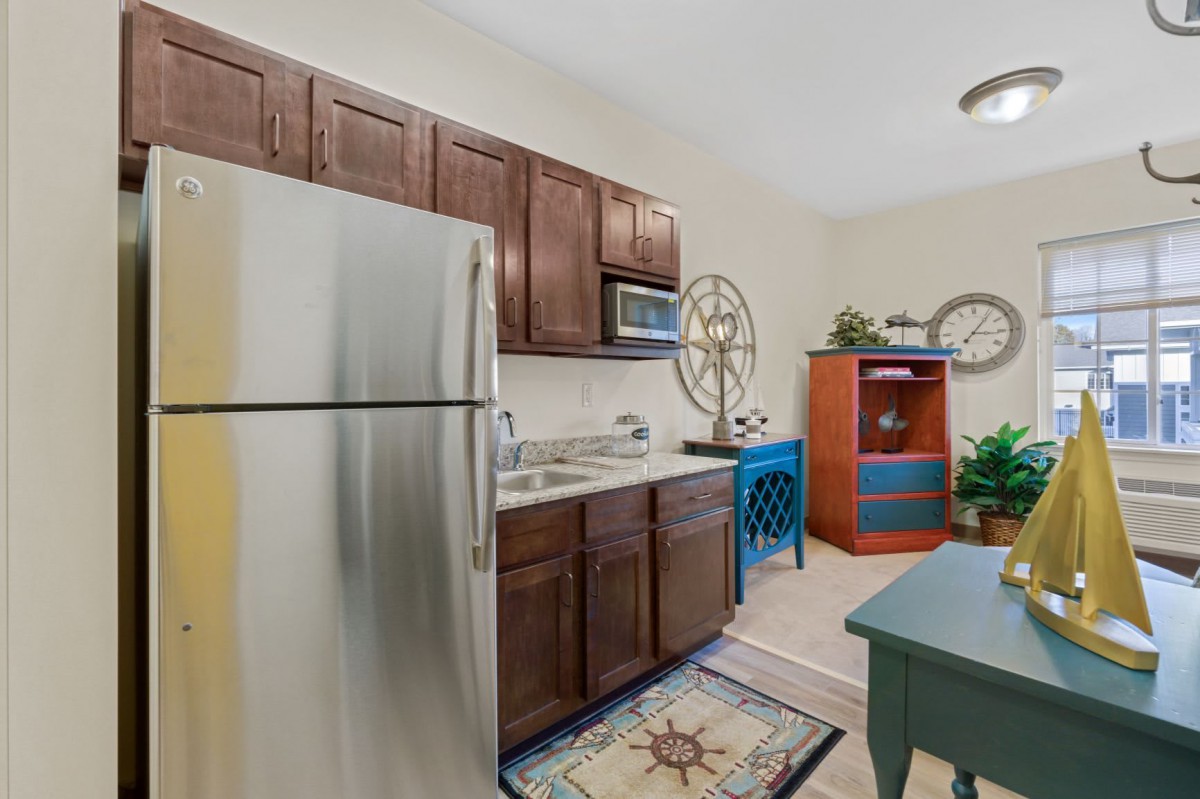 A cozy kitchen with wooden cabinets, stainless steel appliances, and decorative accents.
