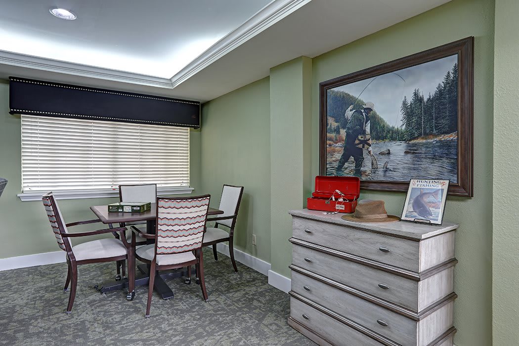 A modern dining area with a table, chairs, and a dresser adorned with decorative items and a large painting on the wall.