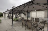 An outdoor patio setup with a gazebo, table, and chairs.