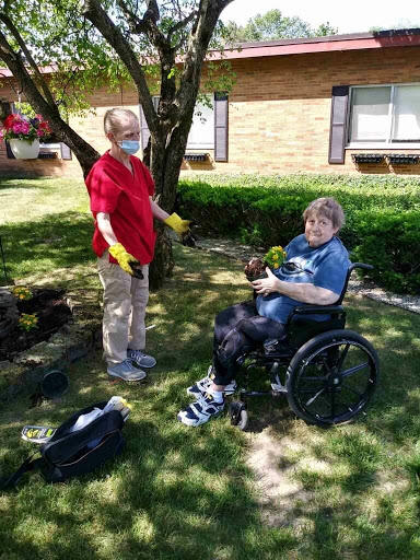 A caregiver assists a person in a wheelchair while enjoying some time outdoors.