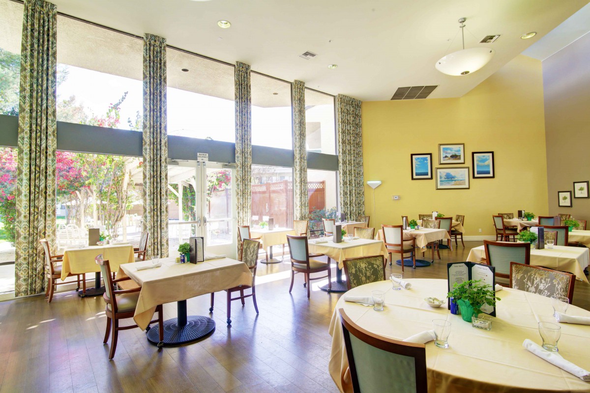 A bright, well-lit restaurant dining area with neatly arranged tables and chairs.